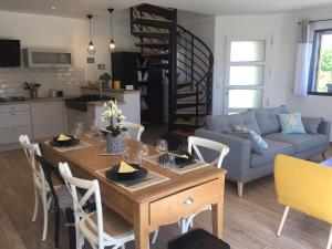 cocina y sala de estar con mesa y sillas en Gîte "Le Bérétyn", en Mont-Dol