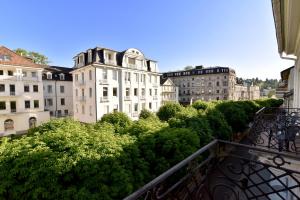 - un balcon avec vue sur les bâtiments et les arbres dans l'établissement Hotel Römerhof, à Baden-Baden