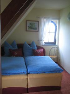 Schlafzimmer mit einem Bett mit blauer Bettwäsche und einem Fenster in der Unterkunft Ferienwohnung TOSCANA in Dresden