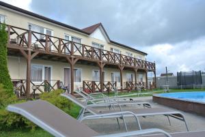 a row of lounge chairs next to a swimming pool at Hotel Grand Sokolniki in Zelenogradsk