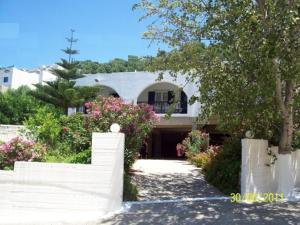 una casa blanca con flores delante en Georgia Studios, en Fourni Ikarias