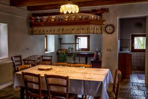 comedor con mesa, sillas y reloj en A casa mia en Meduno