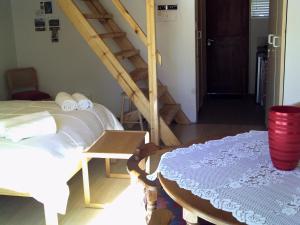 a room with a bed and a staircase with a table at Kozmos in Clarens