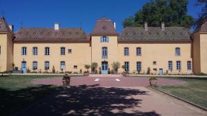 un gran edificio con un patio delante de él en Chateau d'Origny, Chambres d'hotes et Restaurant Gastronomique, en Ouches