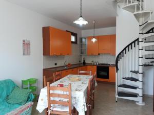 サン・ヴィート・ロ・カーポにあるAppartamenti Giuseppinaのキッチン(テーブル付)、キッチン(オレンジ色のキャビネット付)