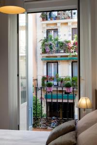 - une chambre avec vue sur un bâtiment orné de plantes en pot dans l'établissement THC Latina Hostel, à Madrid
