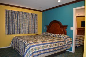 a bedroom with a bed and a blue and yellow wall at Cloud 9 Inn LAX in Inglewood