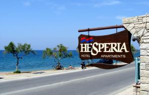 a sign on the side of a road next to the ocean at Hesperia Hotel in Karlovasi