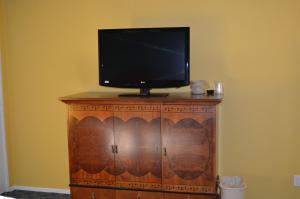 a tv sitting on top of a wooden cabinet at Cloud 9 Inn LAX in Inglewood