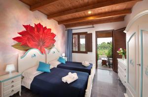 a bed room with a bed and a painting on the wall at Hotel Rurale Orti di Nora & SPA in Santa Margherita di Pula