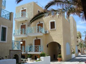 ein Gebäude mit blauen Balkonen und einer Palme in der Unterkunft Hesperia Hotel in Karlovasi