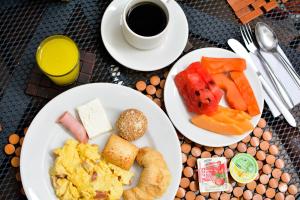 two plates of breakfast food and a cup of coffee at Hotel Karlo By GHO Hoteles in Cali