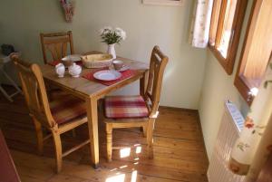 einen Holztisch mit Stühlen und eine Schüssel Blumen darauf in der Unterkunft Ferienwohnung im Schuhhof in Quedlinburg