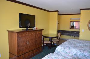 um quarto de hotel com uma cama e uma televisão numa cómoda em Cloud 9 Inn LAX em Inglewood