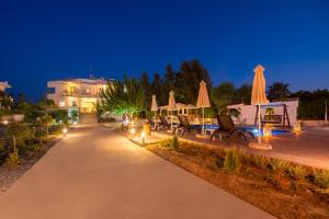法里拉基的住宿－Villa Dora，夜间带椅子和遮阳伞的路径
