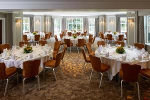 a banquet room with tables and chairs with white linens at The Bull in Gerrards Cross