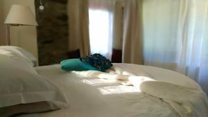 a white bed with white pillows and a window at La Pecora Nera in Rocchetta Nervina