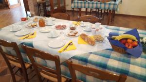 a table with a plate of food and fruit on it at Agriturismo Il Palazzone in Montegalda