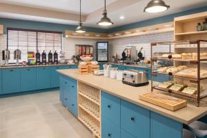 a kitchen with blue cabinets and a counter with bread at Country Inn & Suites by Radisson, Chicago-Hoffman in Hoffman Estates