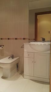 a bathroom with a sink and a toilet at Apartamentos Rapadoira in Foz +32 photos