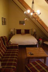 a bedroom with a bed and a couch and a table at Ferienwohnung im Schuhhof in Quedlinburg