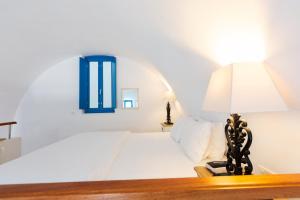a room with a bed and a lamp on top of it at Desiterra Resort in Fira