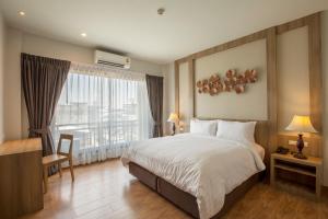 um quarto de hotel com uma cama e uma janela em Civilize Hotel em Udon Thani