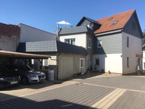 ein Auto parkt auf einem Parkplatz neben einem Haus in der Unterkunft Tom´s Ferienappartements in Tabarz