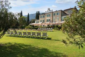 a row of lawn chairs in front of a building at Hotel Du Parc in Garda