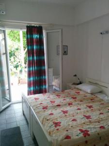 sypialnia z dużym łóżkiem z kwiatami w obiekcie Varagoulis Giannis & Lenas Apartments w mieście Paramonas