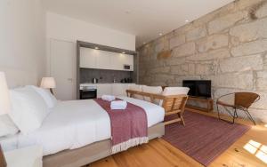ポルトにあるLovelyStay - Allderman Apartment - Almada 3º Fの石壁のベッドルーム1室(大型ベッド1台付)