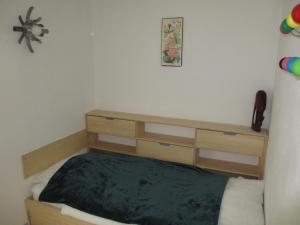 - une chambre avec un lit et une commode en bois dans l'établissement L'appart de Serre Che, à La Salle Les Alpes