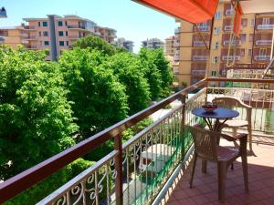 balcón con mesa, sillas y árboles en Appartamento Andora mare, en Andora