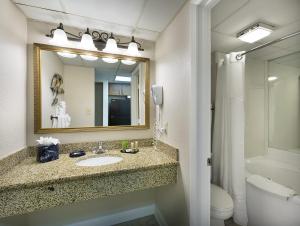 a bathroom with a sink and a mirror and a toilet at Sea Crest Oceanfront Resort in Myrtle Beach