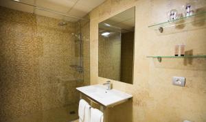 a bathroom with a sink and a shower with a mirror at Elba Castillo San Jorge & Antigua Suite Hotel in Caleta De Fuste