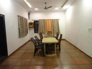 a dining room with a table and chairs at Malhar Bungalow in Panchgani