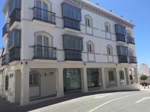 un edificio blanco con balcones negros en una calle en Hostal Boutique Doña Carmen - Adults Recommended, en Nerja
