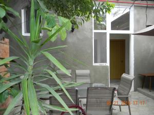 a patio with chairs and a table and a plant at GEO Vake Guest House in Tbilisi City