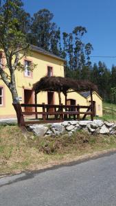 uma casa com uma cerca de madeira e uma árvore em Casa Polo em Loiba