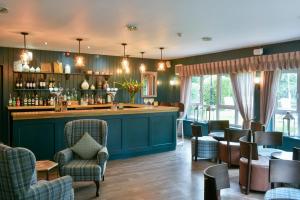 a bar in a restaurant with chairs and tables at Clarion Hotel Charlecote Pheasant in Stratford-upon-Avon