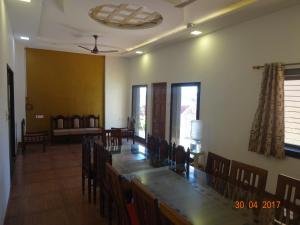 a dining room with a long table and chairs at Malhar Bungalow in Panchgani