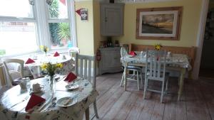 comedor con mesas y sillas y cocina en Hooray Henrys, en Sheringham