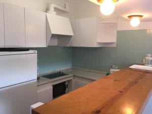 a kitchen with white cabinets and a wooden counter top at Sta Maria Apartment in Tamariu