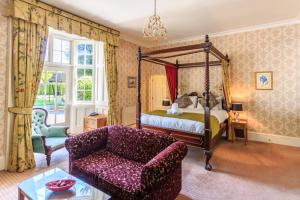 a living room with a canopy bed and a couch at The Charlecote Pheasant in Stratford-upon-Avon