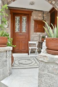 a wooden door with a white chair on a patio at Kassandra House in Hydra