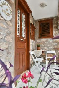 a door to a house with two chairs and a table at Kassandra House in Hydra