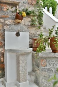 a white mailbox next to a stone wall with potted plants at Kassandra House in Hydra