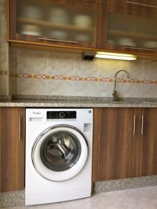 a washing machine sitting under a counter in a kitchen at De Camino vivienda de uso turístico in Arzúa