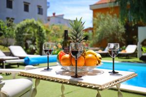 una mesa con un bol de frutas y copas de vino en Apartments Mirakul, en Zadar