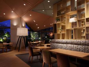 a restaurant with tables and chairs and lights at Hotel Nikko Narita in Narita